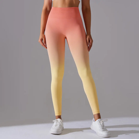 Person wearing a gradient melange yoga pants leggings from orange to yellow on a gray background