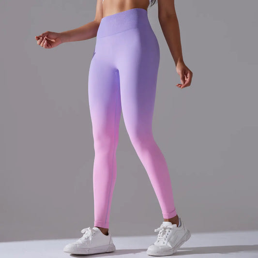 Person wearing gradient purple yoga tights with white sneakers on a gray background